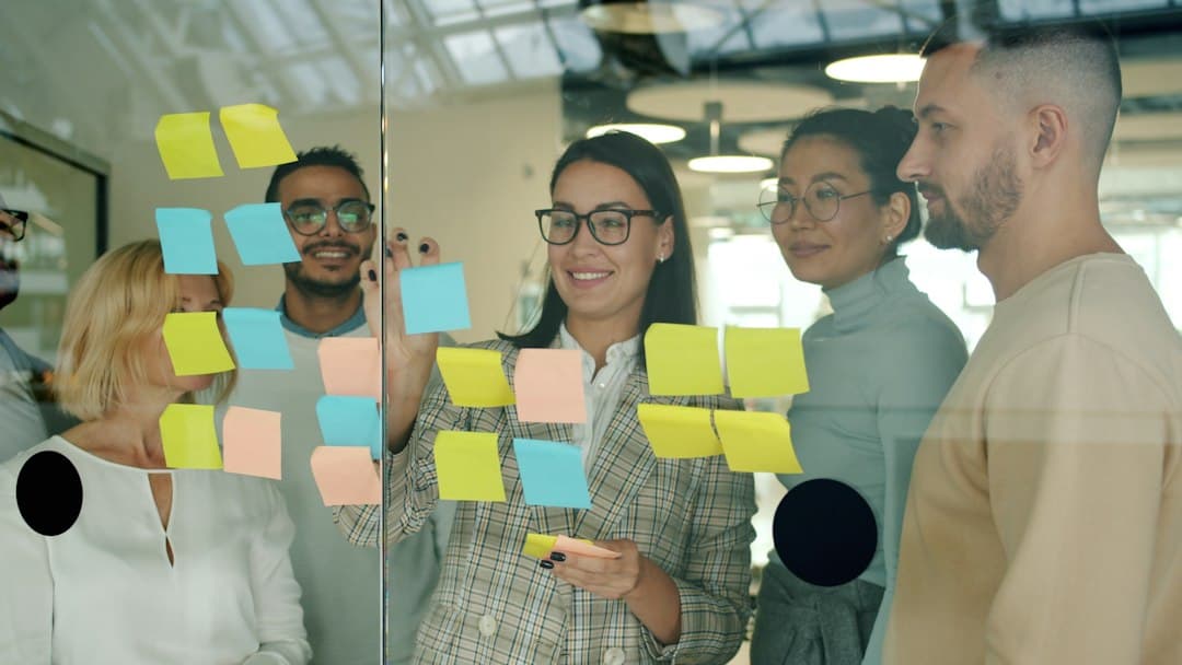 A manager with her team in front of a sticky-note board